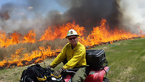 Image of South Dakota Wildland Fire firefighter on a 4-wheeler during a prescribed burn