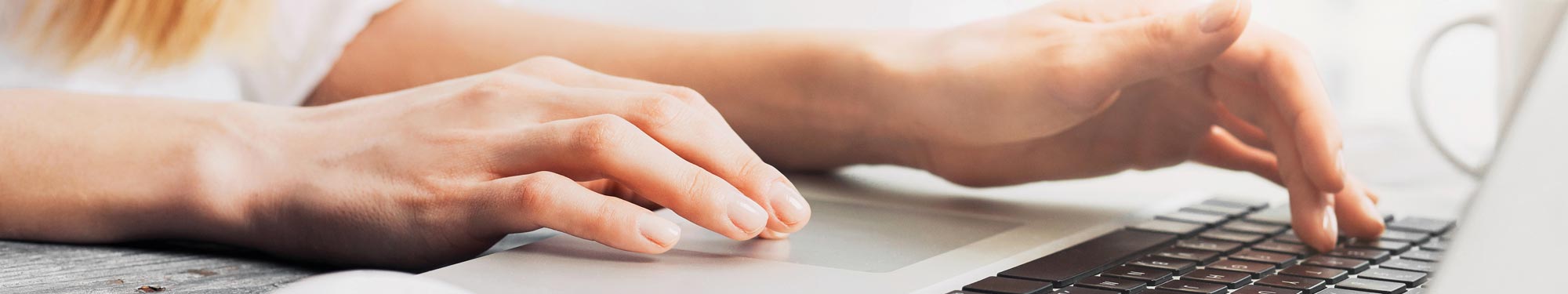 Image of hands typing on a computer keyboard