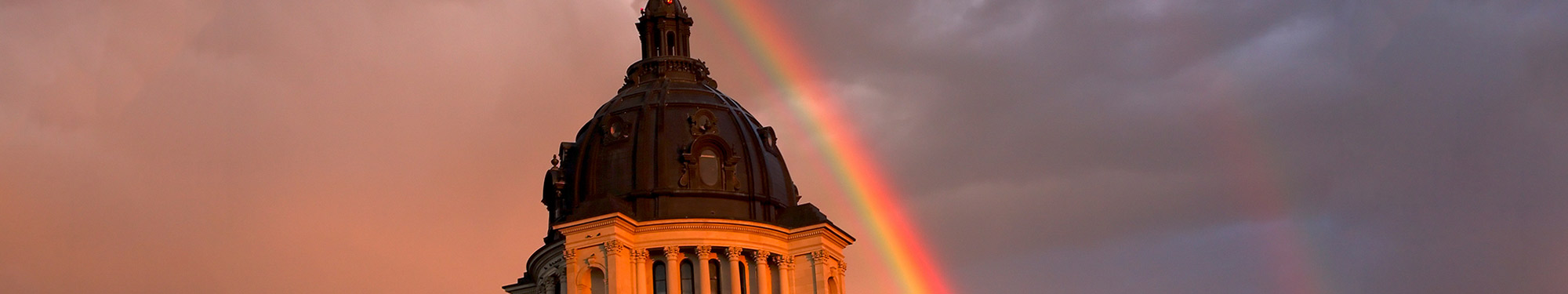 Image of South Dakota's Capitol dome with a rainbow in the background