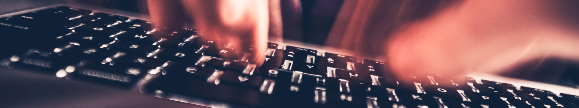 Computer keyboard with hands moving rapidly over the keys