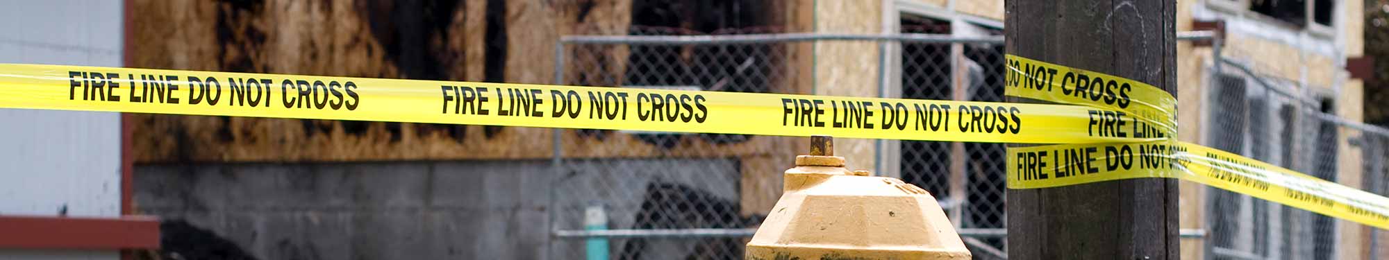 Image of fire line do not cross tape stretched across a fire scene