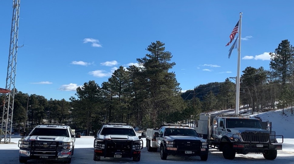 Image of Lead District Office with trucks and flag pole