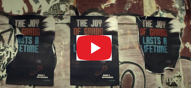 Image of posters on a wall with video player symbol in middle of image