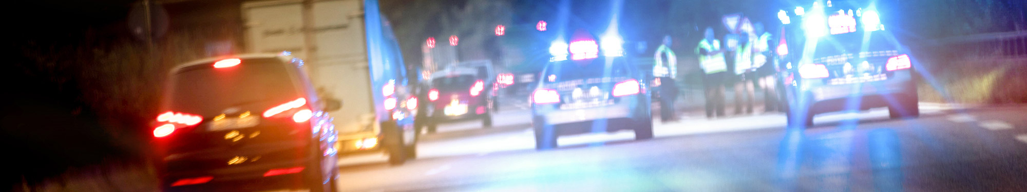 Image of various first responder vehicles with emergency lights flashing on the scene of a car crash