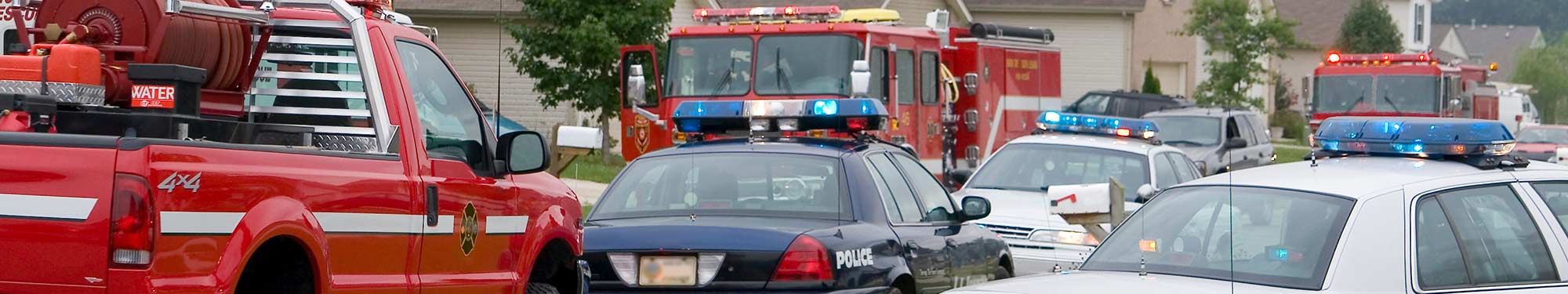 Image of first responder vehicles arriving on a scene during the daytime