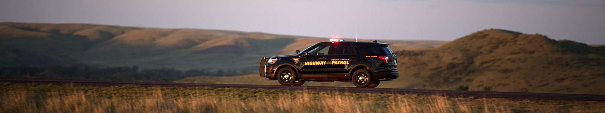 Image of South Dakota Highway Patrol trooper vehicle on highway on the horizon
