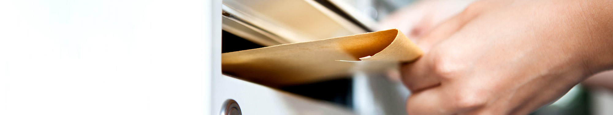 Image of hand putting an envelope in a mailbox