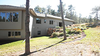 Image of front of house with manicured lawn and brush removed from next to home