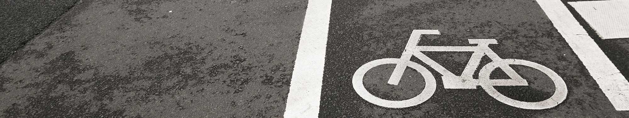 Image of white bicycle lane painted on black roadway