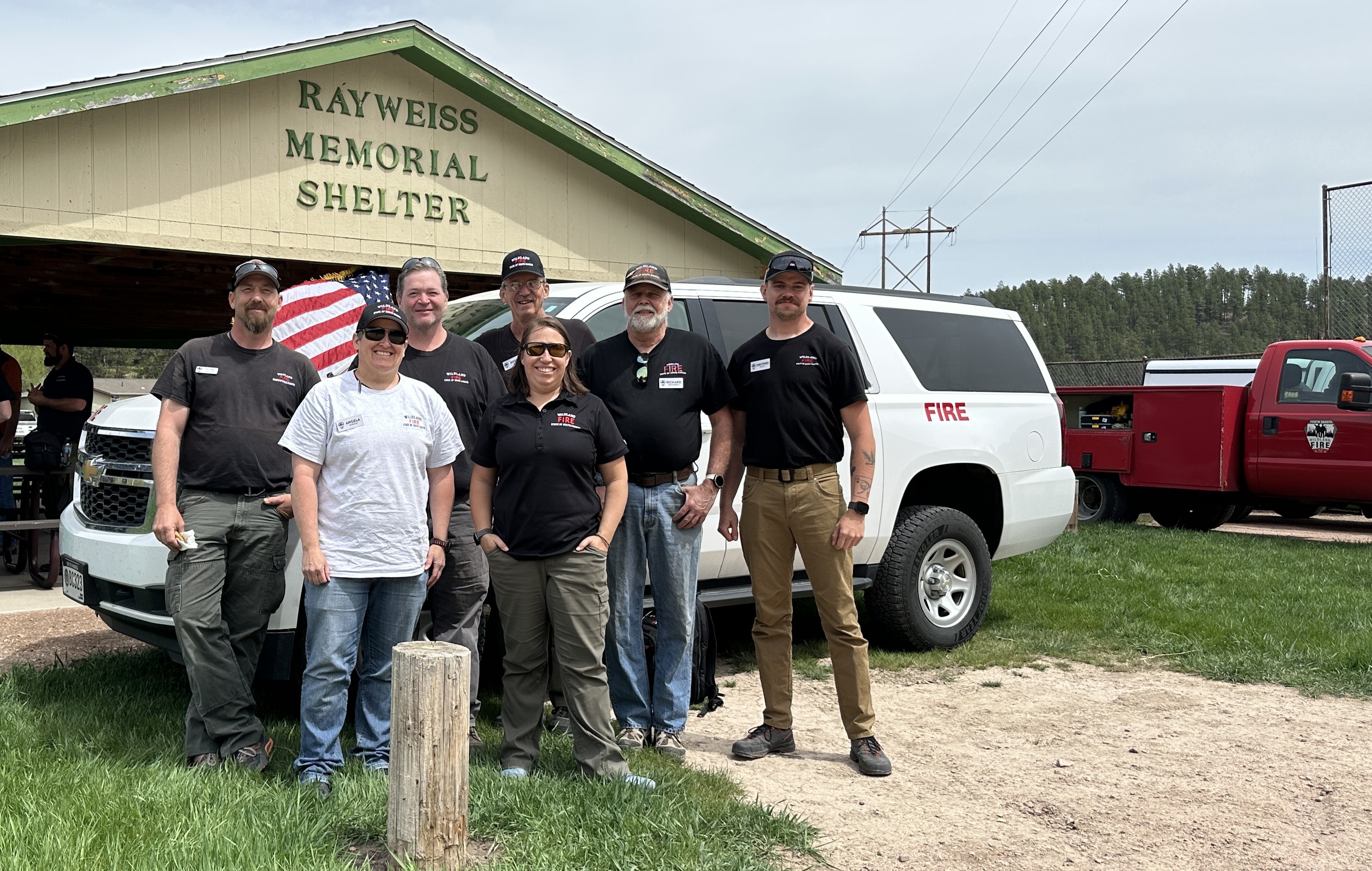 Image of 2025 SD Wildland Fire Aviation crew in front of the Ray Weiss Memorial Shelter