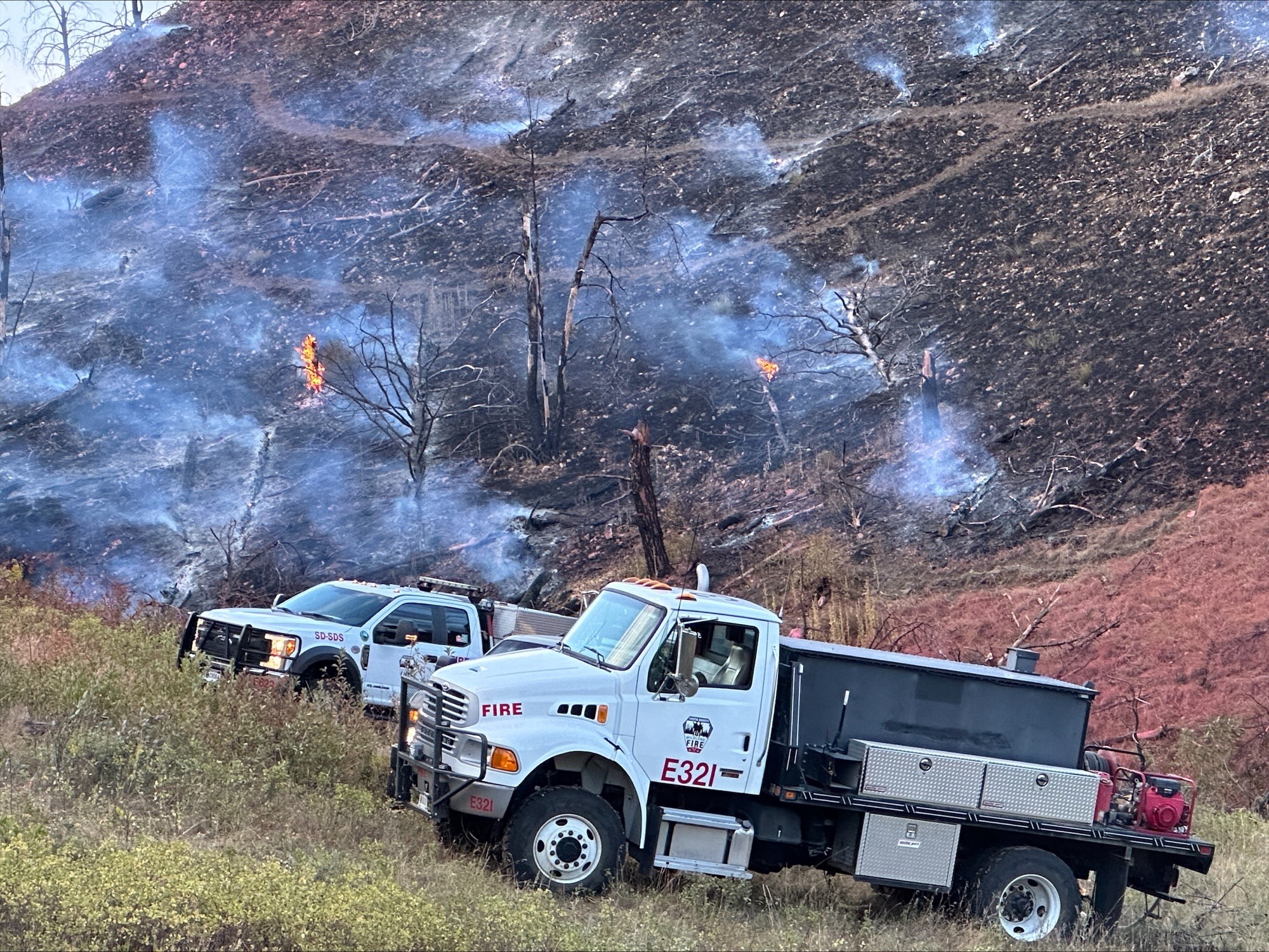 Image of two South Dakota Wildland Fire engines working an active fire