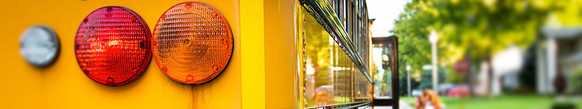 Image of the back of a yellow school bus with red and yellow tail lights